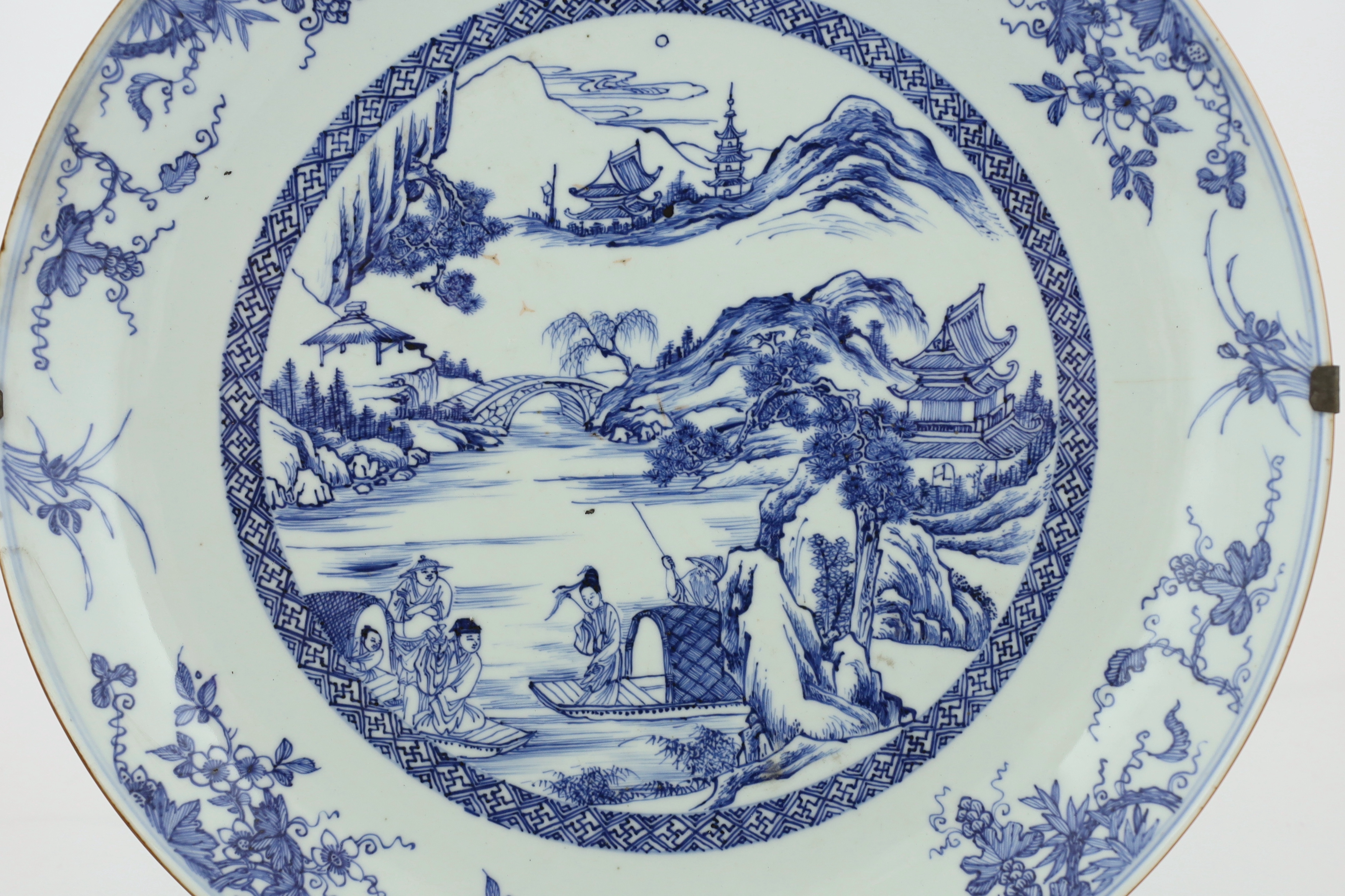 A Chinese blue and white landscape dish, Yongzheng/Qianlong period, short hairline crack